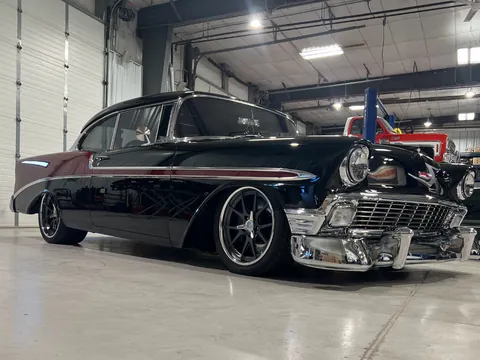 Front three-quarter view of the black 1956 Chevy in the shop